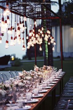 a long table is set up with many plates and glasses for an elegant dinner party