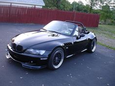 a black convertible car parked in a parking lot