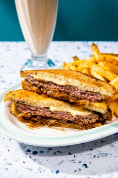 a white plate topped with a sandwich and french fries next to a glass of milk