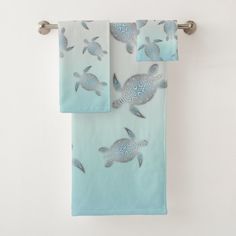 two towels hanging on a towel rack with sea turtles printed on the front and back