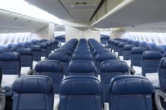 rows of empty blue seats in an airplane