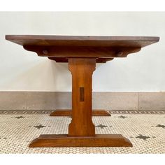 a wooden table sitting on top of a tiled floor