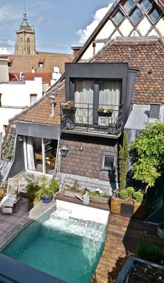 an aerial view of a house with a swimming pool in the foreground and a steeple to the right