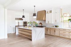 a large kitchen with wooden cabinets and white marble counter tops, along with wood flooring