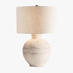 a white table lamp with a beige shade