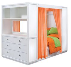 a bed with an orange and green cover on it's headboard is next to a white dresser