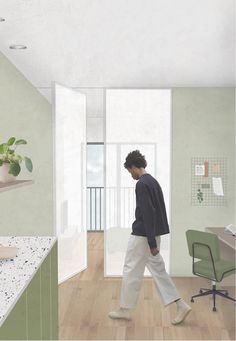 a man walking through a room with a desk and chair