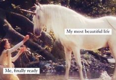 a white horse standing next to a woman in the water with her hand on it's face