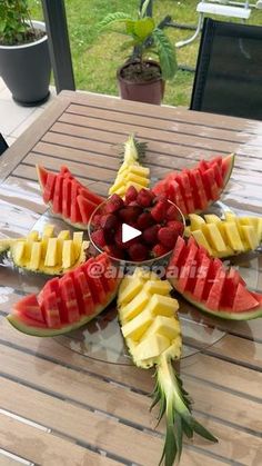 watermelon slices, pineapples and strawberries arranged on a glass plate