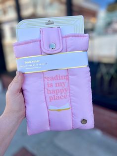 someone is holding up a pink case that says reading is my happy place