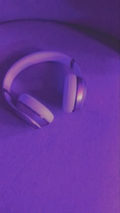 a pair of headphones sitting on top of a purple surface