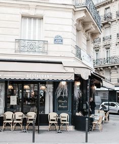 the outside of a restaurant with tables and chairs on the sidewalk in front of it