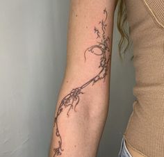 a woman's arm with a vine tattoo on the left side of her arm