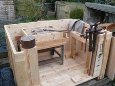 an outdoor work bench made out of pallets and wooden planks with tools attached to it