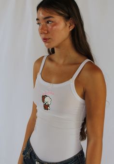 With three hand-sewn pink bows, the Hugging Bears embroidered top is a must-have piece.   Model is wearing a size small Fitted Graphic Print Cute Tank Top, White Tank Crop Top For Streetwear, White Y2k Cotton Tank Top, White Cotton Y2k Tank Top, White Cotton Y2k Style Tank Top, Fitted White Y2k Tank Top, White Fitted Y2k Tank Top, Cute Sleeveless Streetwear Tops, White 90s Tank Top For Streetwear