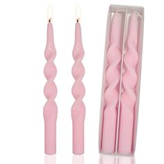 three pink candles are in a box and one is turned upside down