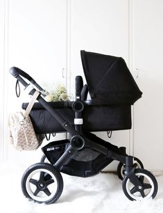 a black stroller sitting on top of a white rug