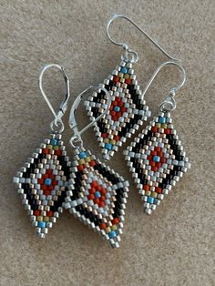 two pairs of beaded earrings sitting on top of a carpet