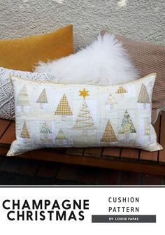 two pillows sitting on top of a wooden bench next to a pillow with christmas trees