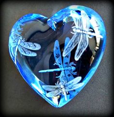 a glass heart with dragonflies on it