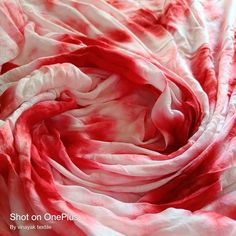 the red and white fabric has been dyed to look like it is flowing in the wind