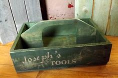 a green wooden tool box sitting on top of a hard wood floor