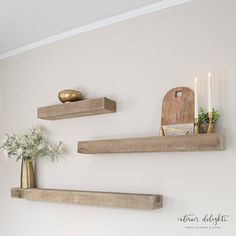 two wooden shelves with candles and vases on them