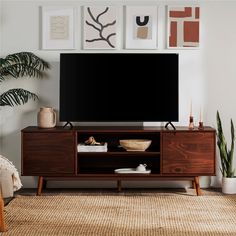 a flat screen tv sitting on top of a wooden entertainment center in a living room