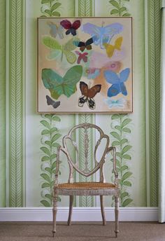 a chair sitting in front of a painting on the wall