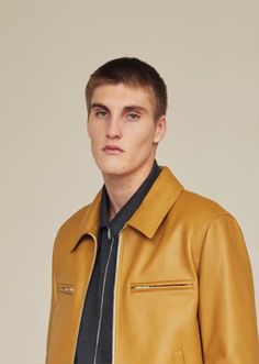 a young man in a yellow leather jacket