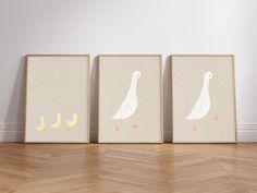 three framed pictures with ducks on them in front of a white wall and wooden floor