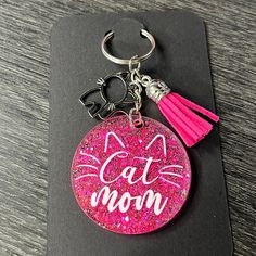 a pink glitter keychain with the words cat moon on it and a tassel