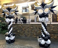 two black and white balloon sculptures in front of a building