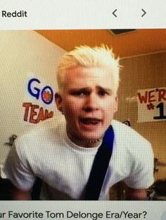 a man with blonde hair wearing a white t - shirt