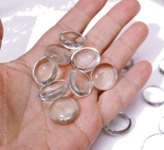 a person's hand holding several glass objects in their palm, with rings around them