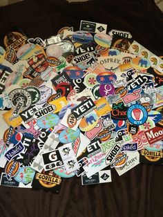 a pile of various stickers sitting on top of a brown bed cover covered in black and white sheets