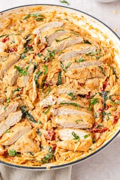 a pan filled with chicken and pasta on top of a table