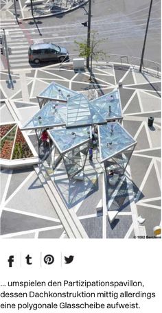 an aerial view of a glass house in the middle of a street with cars driving on it