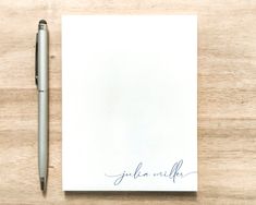 a notepad with the word julia written on it next to a ballpoint pen