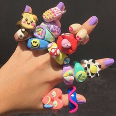 a person's hand holding several rings with different designs on them, all in various shapes and sizes