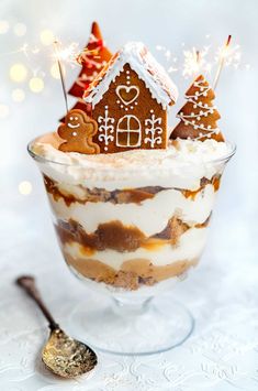 a dessert in a glass with gingerbread house decorations on top