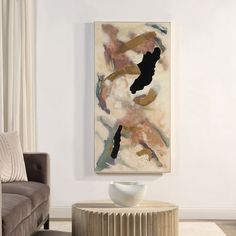 an abstract painting hangs on the wall next to a couch