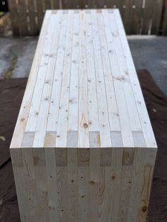 a wooden bench sitting on top of a piece of wood