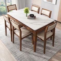 a dining room table with chairs and a vase on it in front of a window