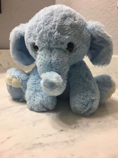 a blue stuffed elephant sitting on top of a counter