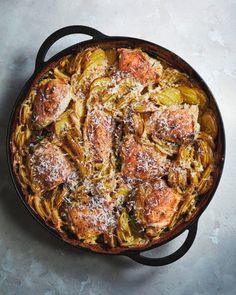 a pan filled with meat and vegetables covered in parmesan cheese