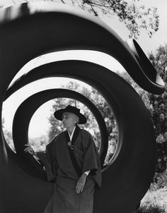 an old man standing in front of a sculpture