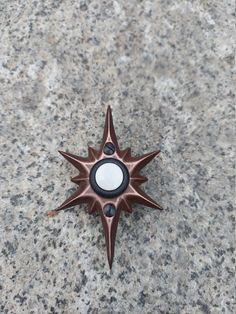 a star shaped object sitting on top of a stone floor next to a black dot