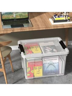 a plastic storage box with books in front of a laptop