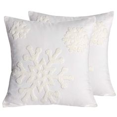 two white pillows with embroidered snowflakes on them